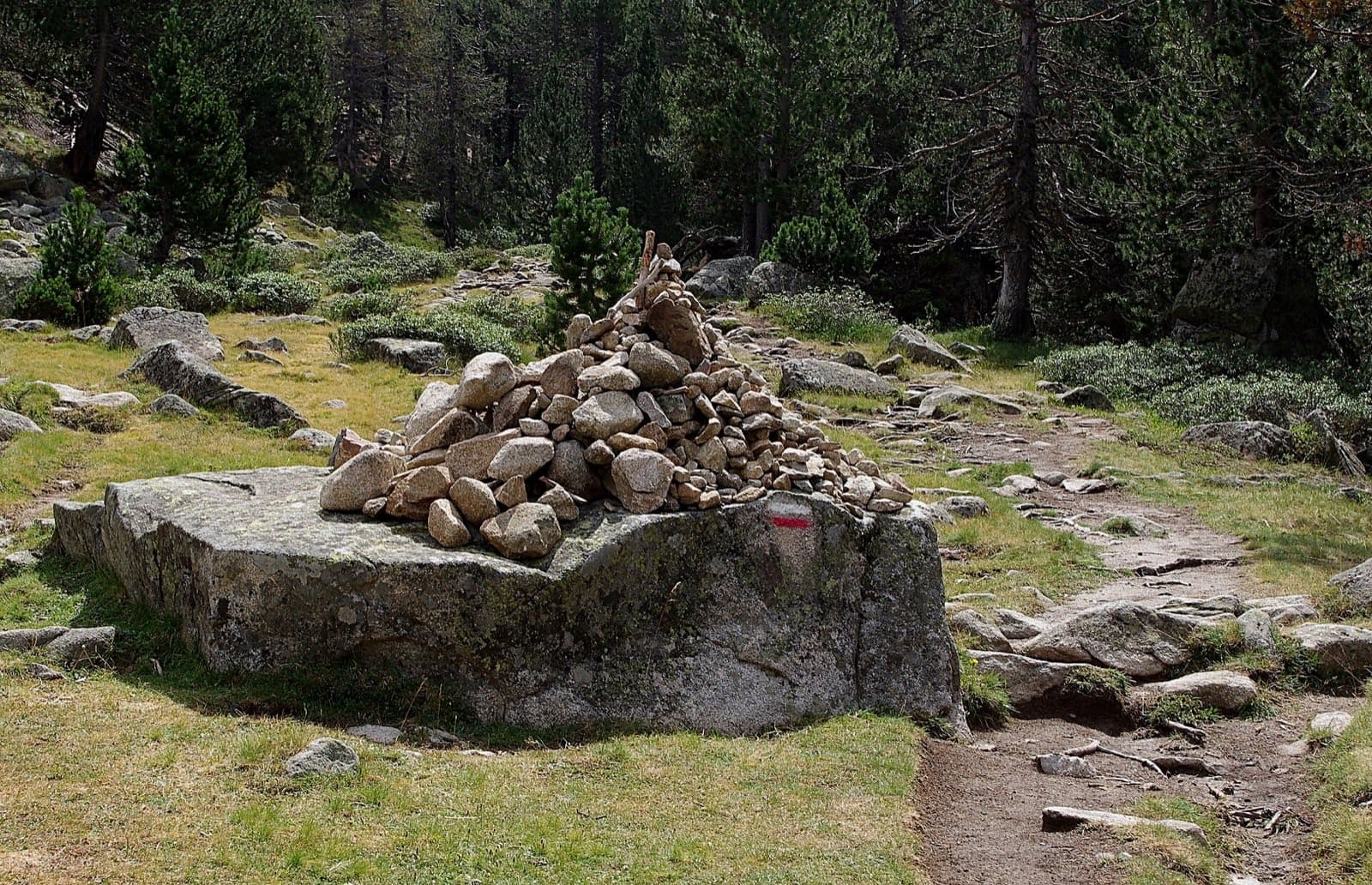 Kamenná mohyla značící GR10 ve francouzských Pyrenejích u Aigues Cluzes