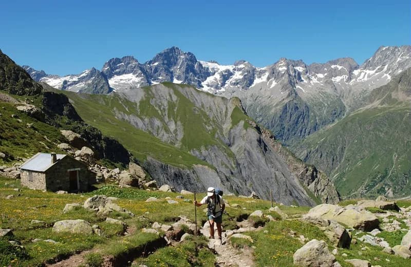 Turista na stezce pod horskými štíty masivu Ecrins